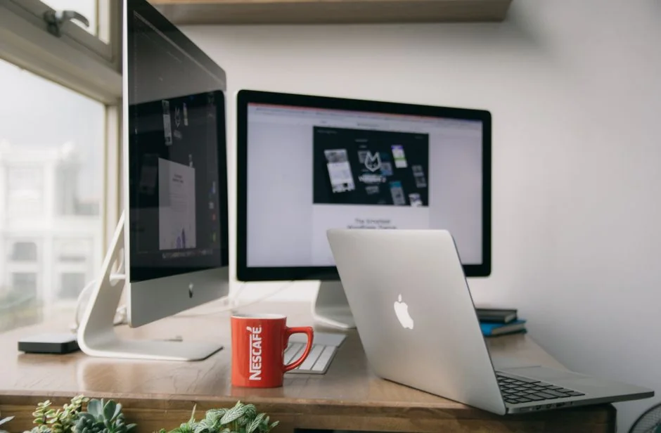 High-angle view of a stylish work desk featuring dual monitors, keyboard, mouse, and modern accessories.